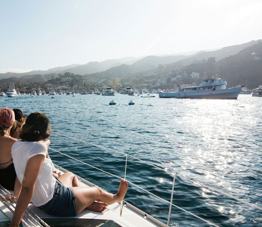 people on deck of catamaran looking at catalina island as they head to dock 