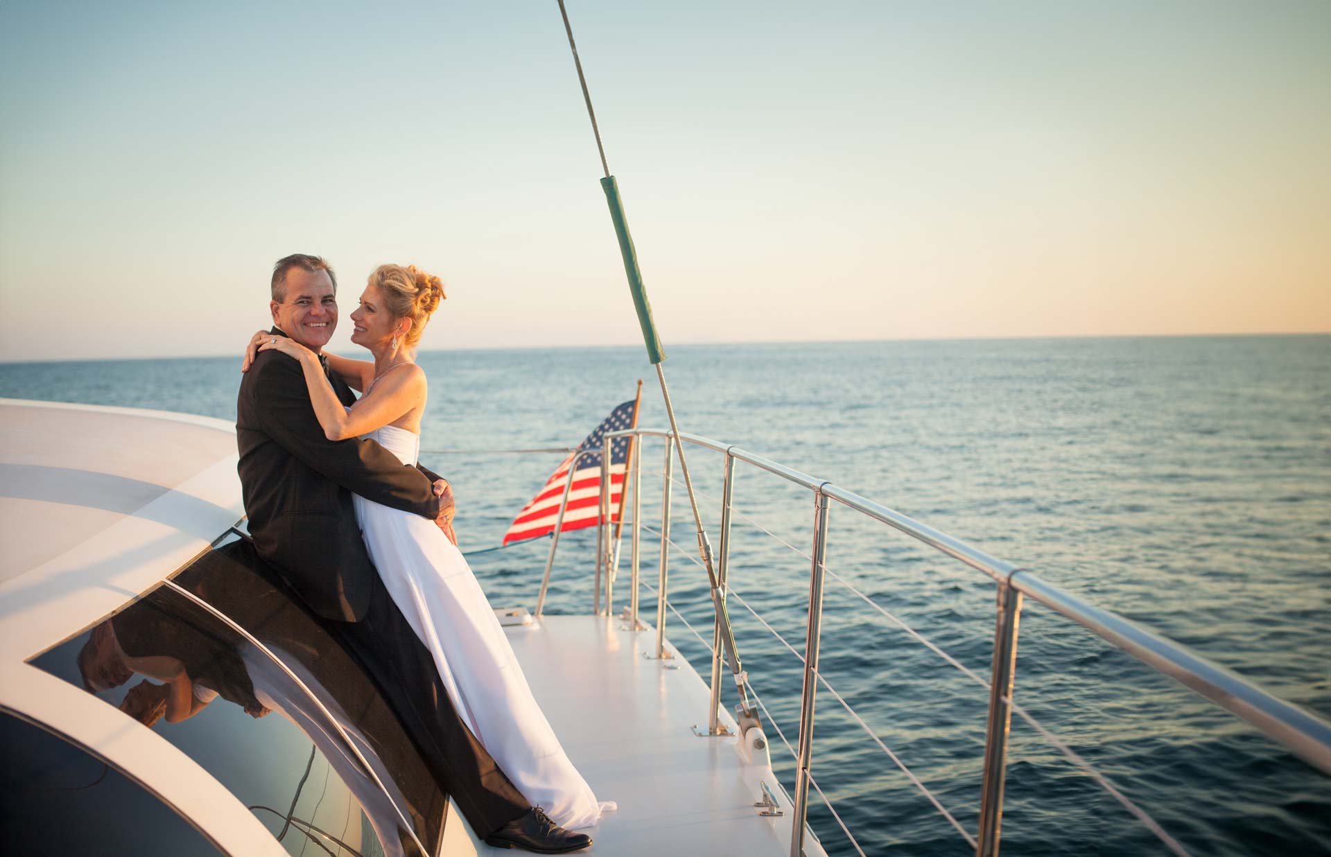 couple on a boat embrace during their wedding party