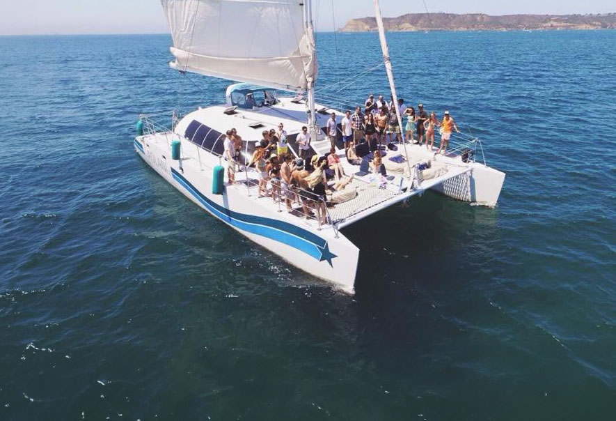 catamaran sailing in san diego as people enjoying a day cruise