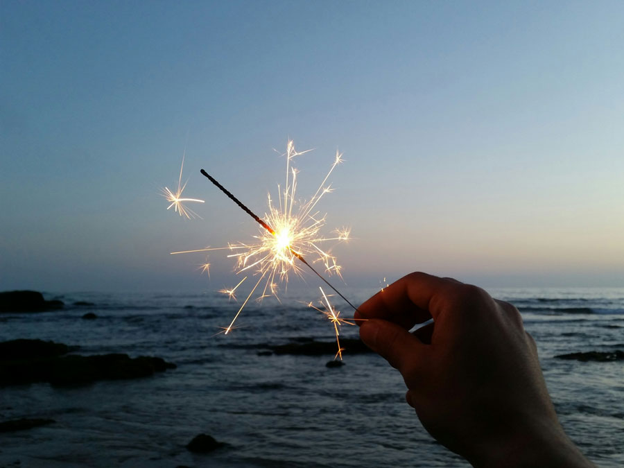 person holds sparkler to represent the celebration for holiday events san diego christmas thanksgiving